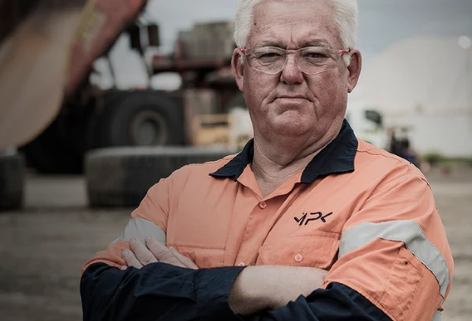 Man in workwear with arms folded